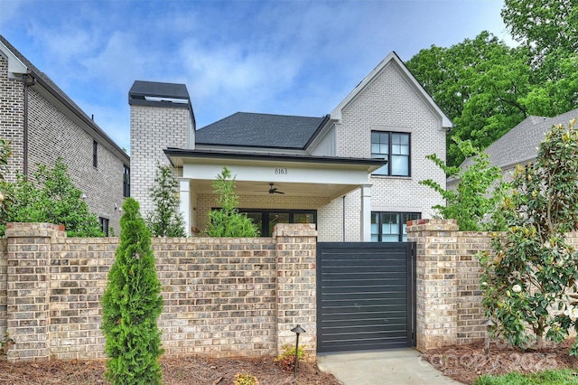 view of front of house featuring a gate, brick siding, and fence private yard