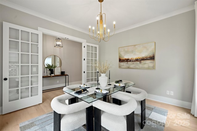 dining space featuring wood finished floors, an inviting chandelier, ornamental molding, and french doors