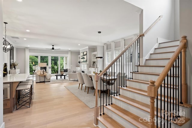 staircase with recessed lighting, ceiling fan, and wood finished floors