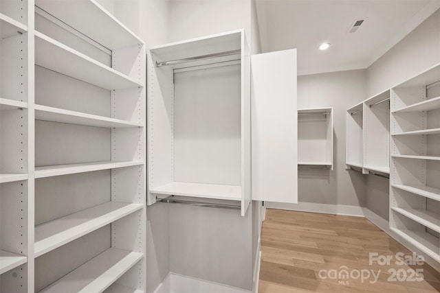 walk in closet featuring visible vents and wood finished floors