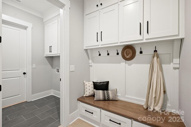 mudroom featuring dark tile patterned floors and baseboards