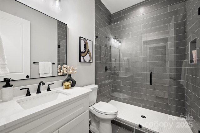 bathroom with vanity, toilet, and a stall shower