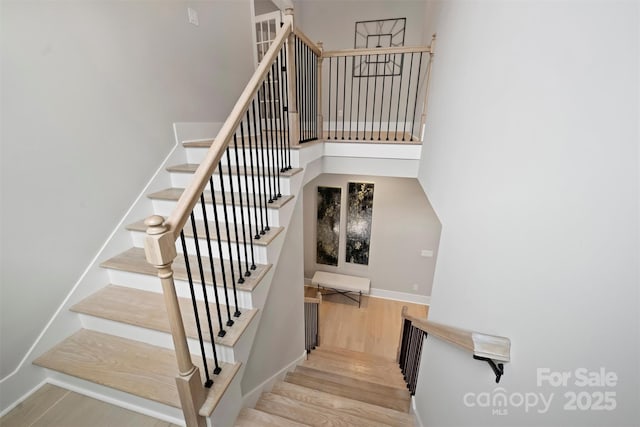 stairs with wood finished floors and baseboards