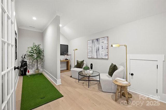 sitting room with lofted ceiling, crown molding, baseboards, recessed lighting, and wood finished floors