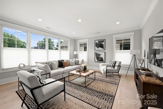 living area featuring ornamental molding, light wood finished floors, recessed lighting, and baseboards