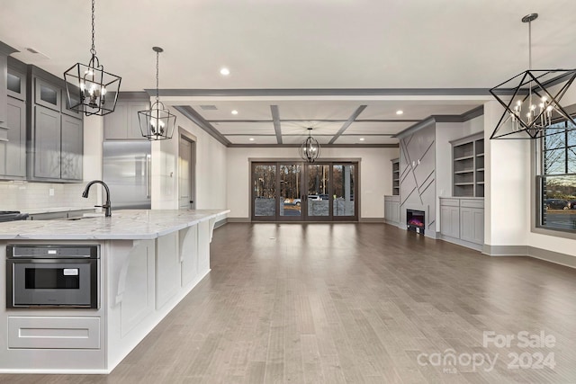 kitchen featuring pendant lighting, tasteful backsplash, stainless steel appliances, and light hardwood / wood-style flooring