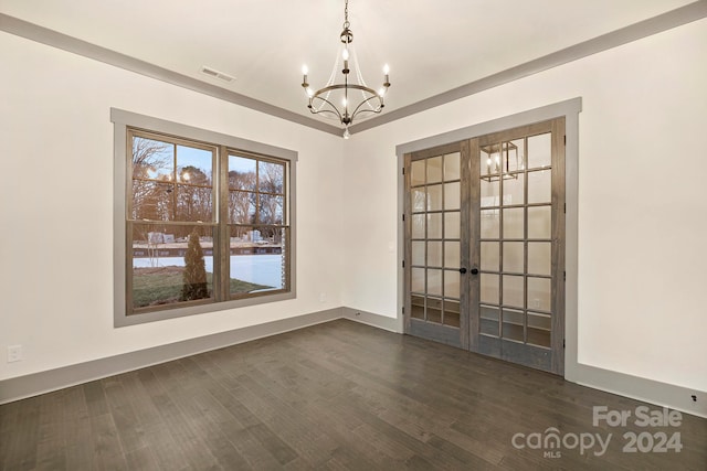 unfurnished room with an inviting chandelier, dark wood-type flooring, and french doors