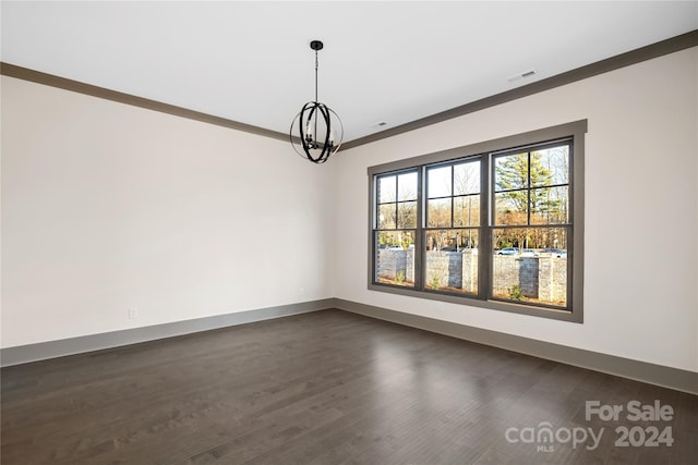 spare room featuring crown molding, dark hardwood / wood-style flooring, and a notable chandelier