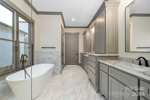 bathroom with a tub, crown molding, tile floors, and vanity