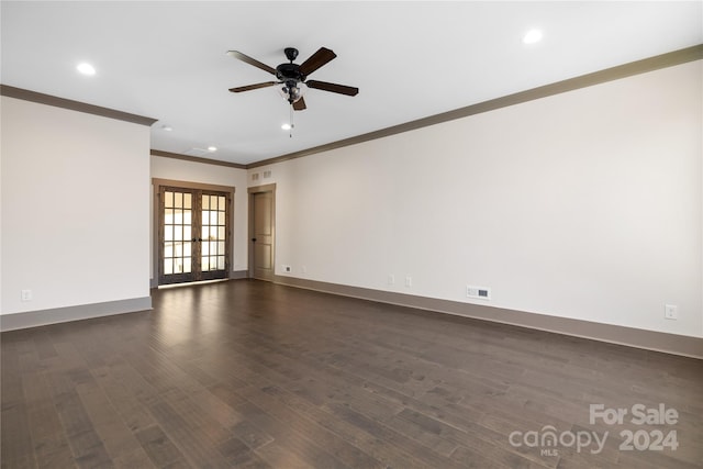 empty room featuring french doors, ornamental molding, ceiling fan, and dark wood-type flooring