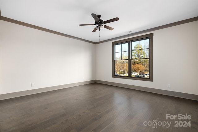 spare room with dark hardwood / wood-style floors, ornamental molding, and ceiling fan