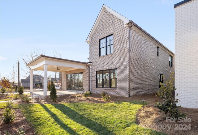 back of house featuring a yard, ceiling fan, and a patio