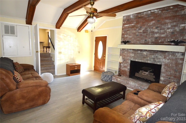 living room featuring lofted ceiling with beams, light hardwood / wood-style floors, ceiling fan, and a fireplace