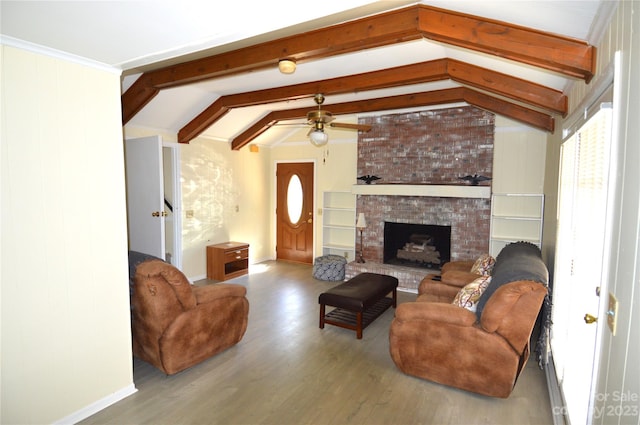 living room featuring brick wall, a brick fireplace, ceiling fan, light hardwood / wood-style flooring, and vaulted ceiling with beams