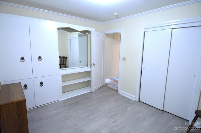 unfurnished bedroom with light hardwood / wood-style floors, ornamental molding, and a closet