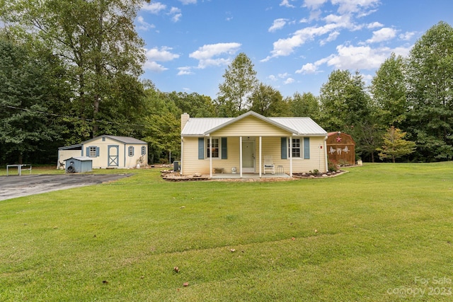 ranch-style house with a porch, a storage shed, and a front yard