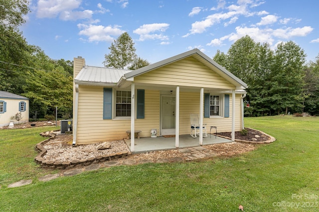 view of front facade featuring a front yard, central AC unit, and a patio area