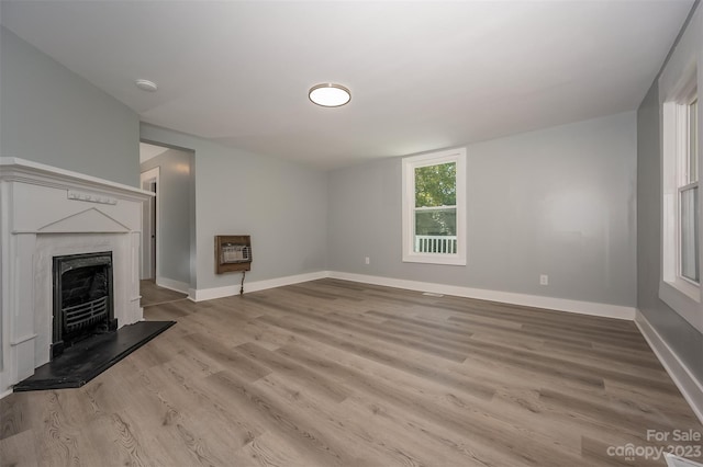 unfurnished living room featuring a high end fireplace and light hardwood / wood-style floors