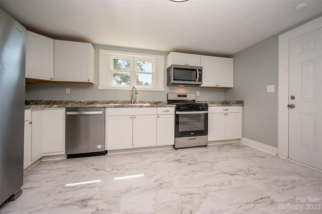 kitchen featuring stainless steel appliances, white cabinets, light tile floors, and sink