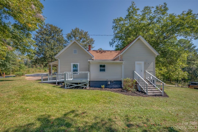 back of house with a deck and a yard