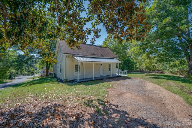 view of property exterior with a yard and a porch