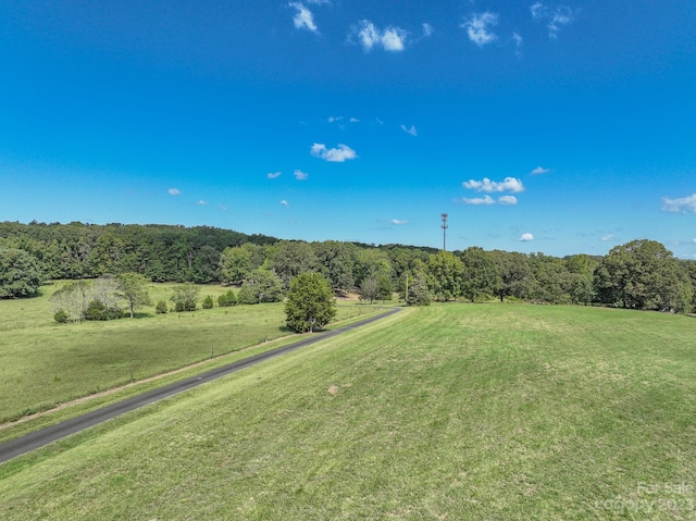 exterior space featuring a rural view and a yard