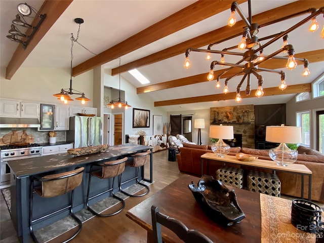 kitchen featuring high quality appliances, a notable chandelier, a breakfast bar, white cabinetry, and dark hardwood / wood-style floors