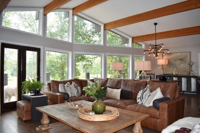 living room featuring plenty of natural light, beam ceiling, dark hardwood / wood-style flooring, and an inviting chandelier