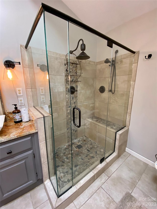 bathroom with tile flooring, an enclosed shower, and vanity