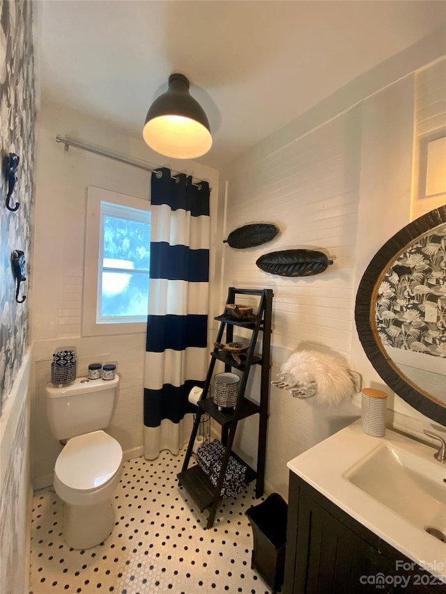 bathroom featuring tile flooring, toilet, and vanity