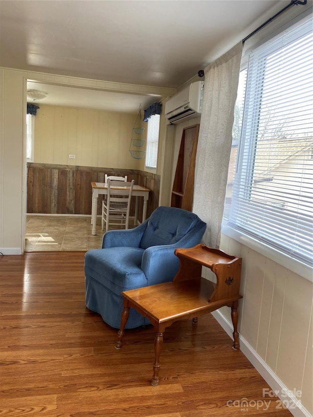 living area with light wood-type flooring and a wall mounted air conditioner