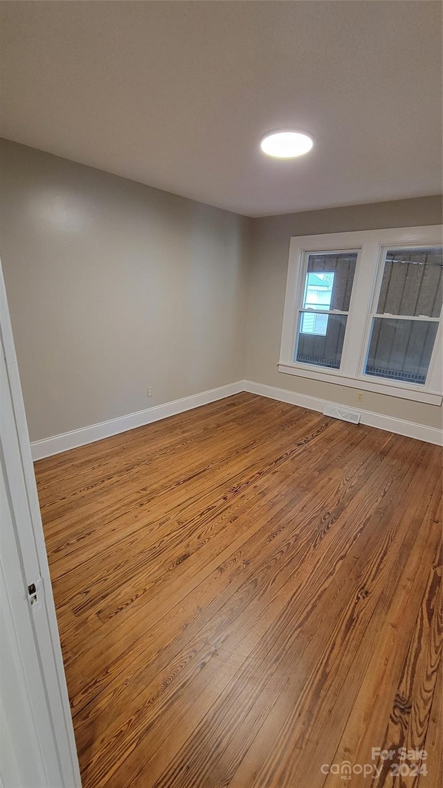 spare room with wood-type flooring