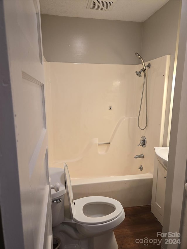 full bathroom with toilet, vanity, shower / bath combination, and hardwood / wood-style flooring