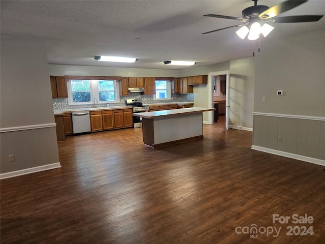 kitchen with backsplash, a center island, sink, appliances with stainless steel finishes, and dark hardwood / wood-style flooring