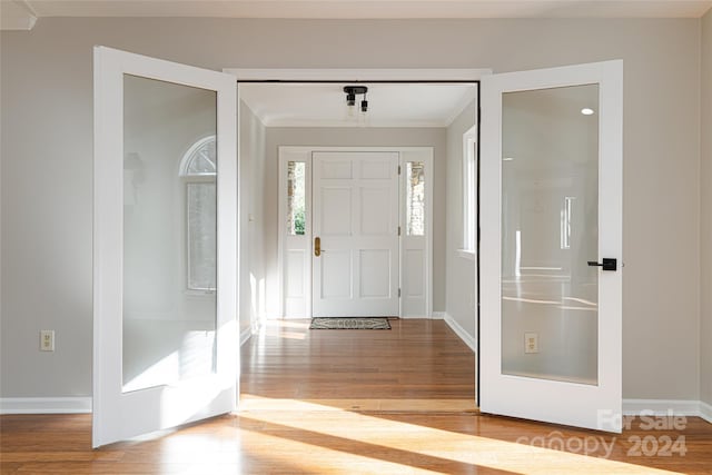 foyer entrance with crown molding and hardwood / wood-style flooring