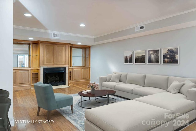 living room featuring light hardwood / wood-style floors and crown molding