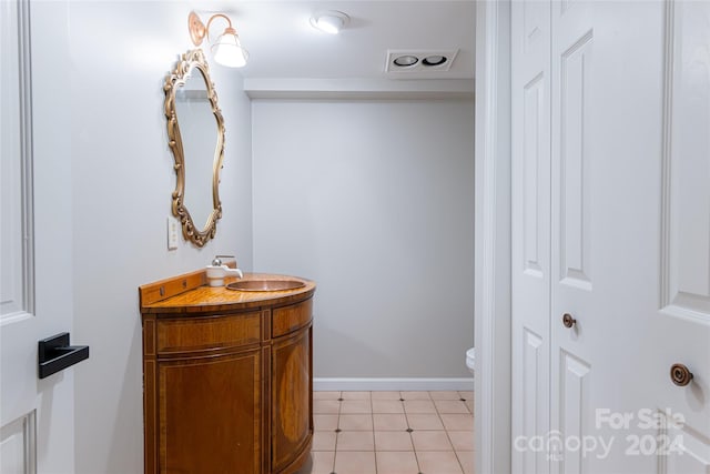 bathroom with tile flooring, vanity, and toilet