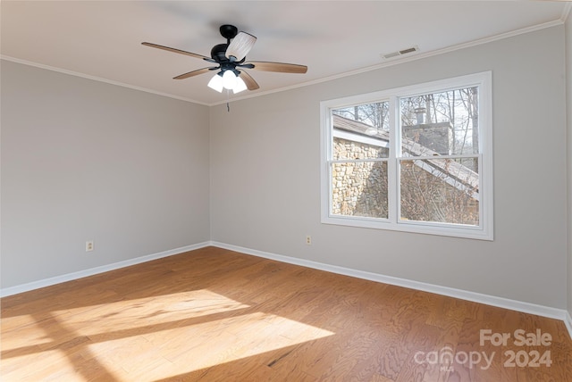 empty room featuring light hardwood / wood-style floors, ornamental molding, and ceiling fan