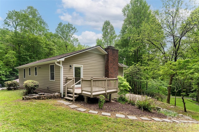 back of property with a lawn and a wooden deck