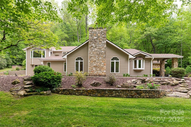 380 Old Powell Rd, Brevard, NC 28712 - view of front facade featuring a shingled roof, a front yard, a forest view, and a chimney