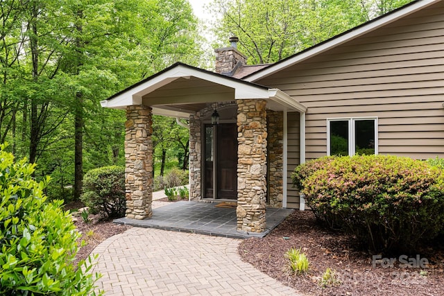 380 Old Powell Rd, Brevard, NC 28712 - view of exterior entry with stone siding and a chimney