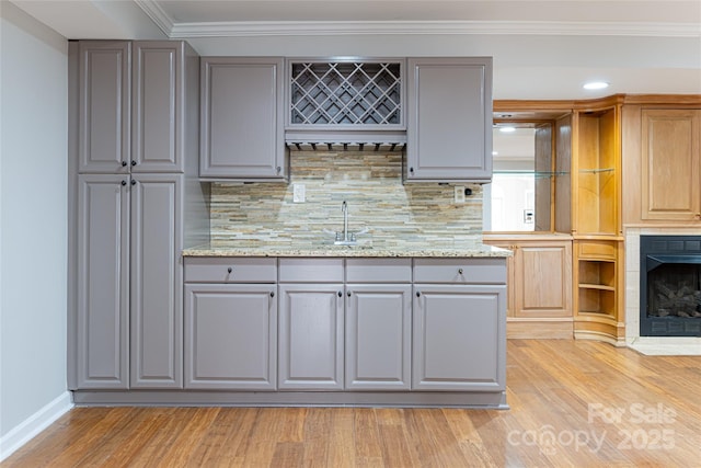 380 Old Powell Rd, Brevard, NC 28712 - kitchen featuring decorative backsplash, gray cabinetry, ornamental molding, and light wood finished floors