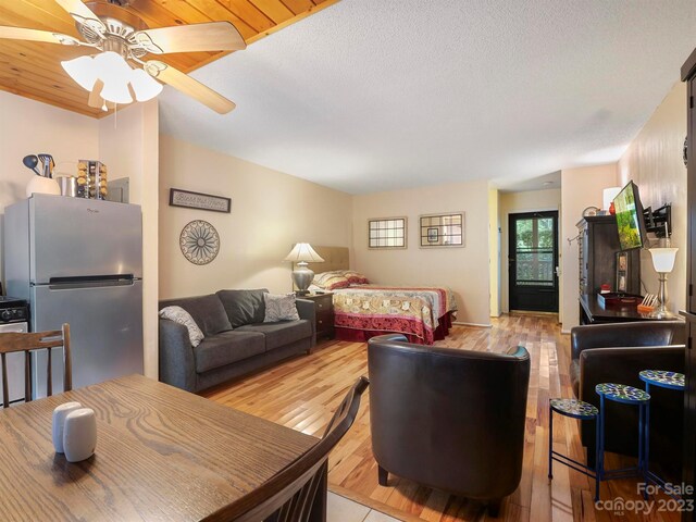 living room featuring a textured ceiling, light hardwood / wood-style floors, ceiling fan, and wood ceiling