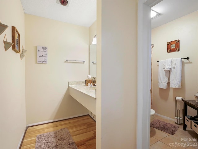 bathroom with hardwood / wood-style flooring, vanity, and toilet