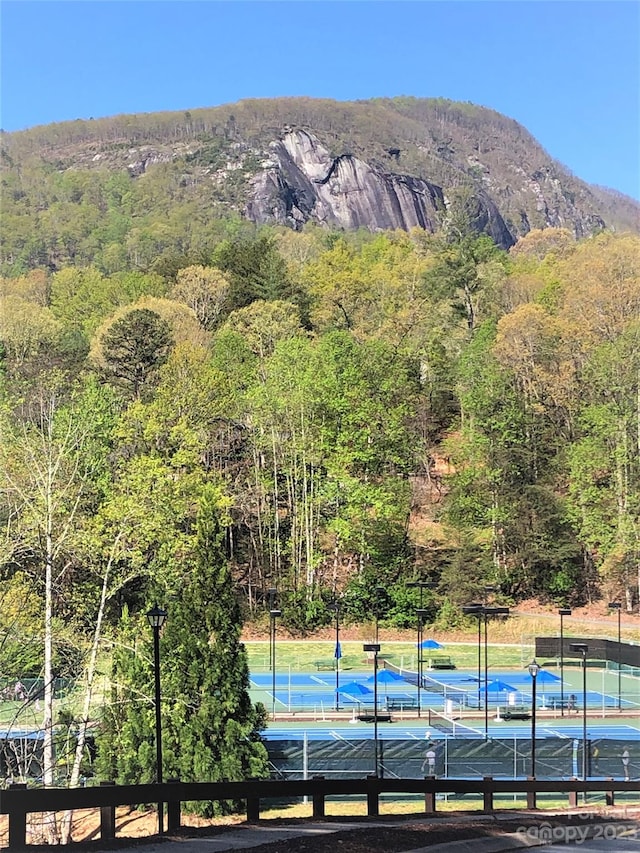 view of swimming pool featuring tennis court and a mountain view