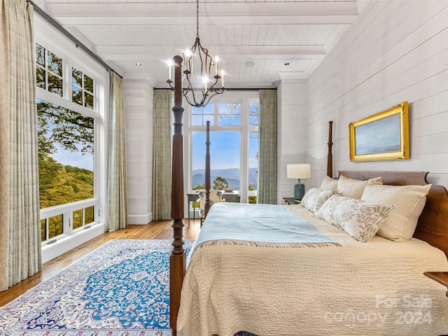 616 Old Growth Forest Rd, Burnsville, NC 28714 - bedroom with beamed ceiling, a chandelier, multiple windows, and wood finished floors