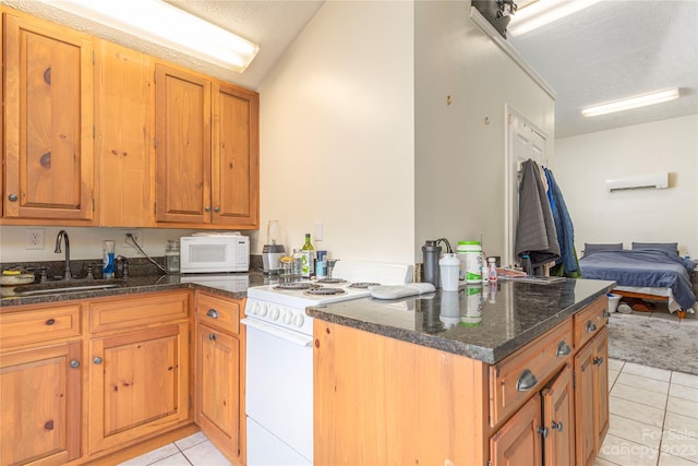 kitchen with kitchen peninsula, white appliances, sink, light tile floors, and dark stone countertops