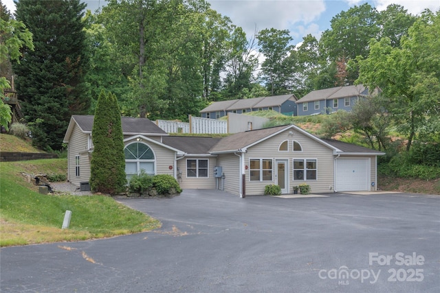 single story home with aphalt driveway