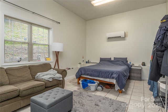 bedroom featuring baseboards, a wall mounted AC, and light tile patterned flooring