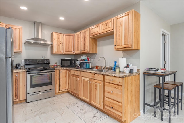 kitchen featuring light brown cabinetry, a sink, marble finish floor, wall chimney range hood, and appliances with stainless steel finishes